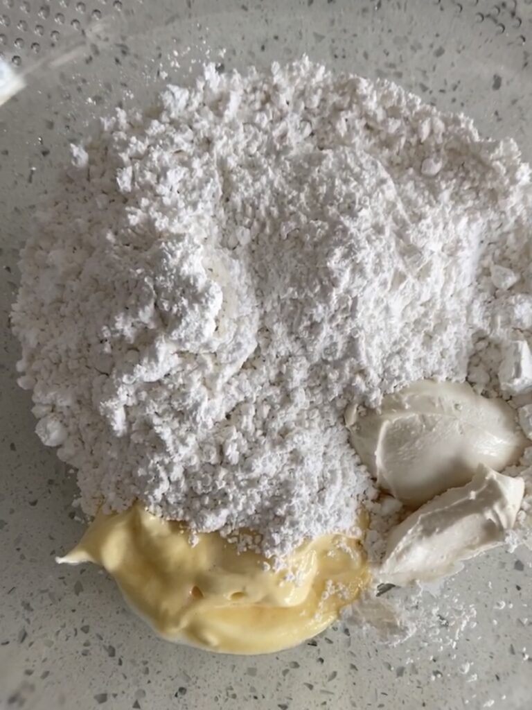 mixing vegan cream cheese and butter with powdered sugar. 