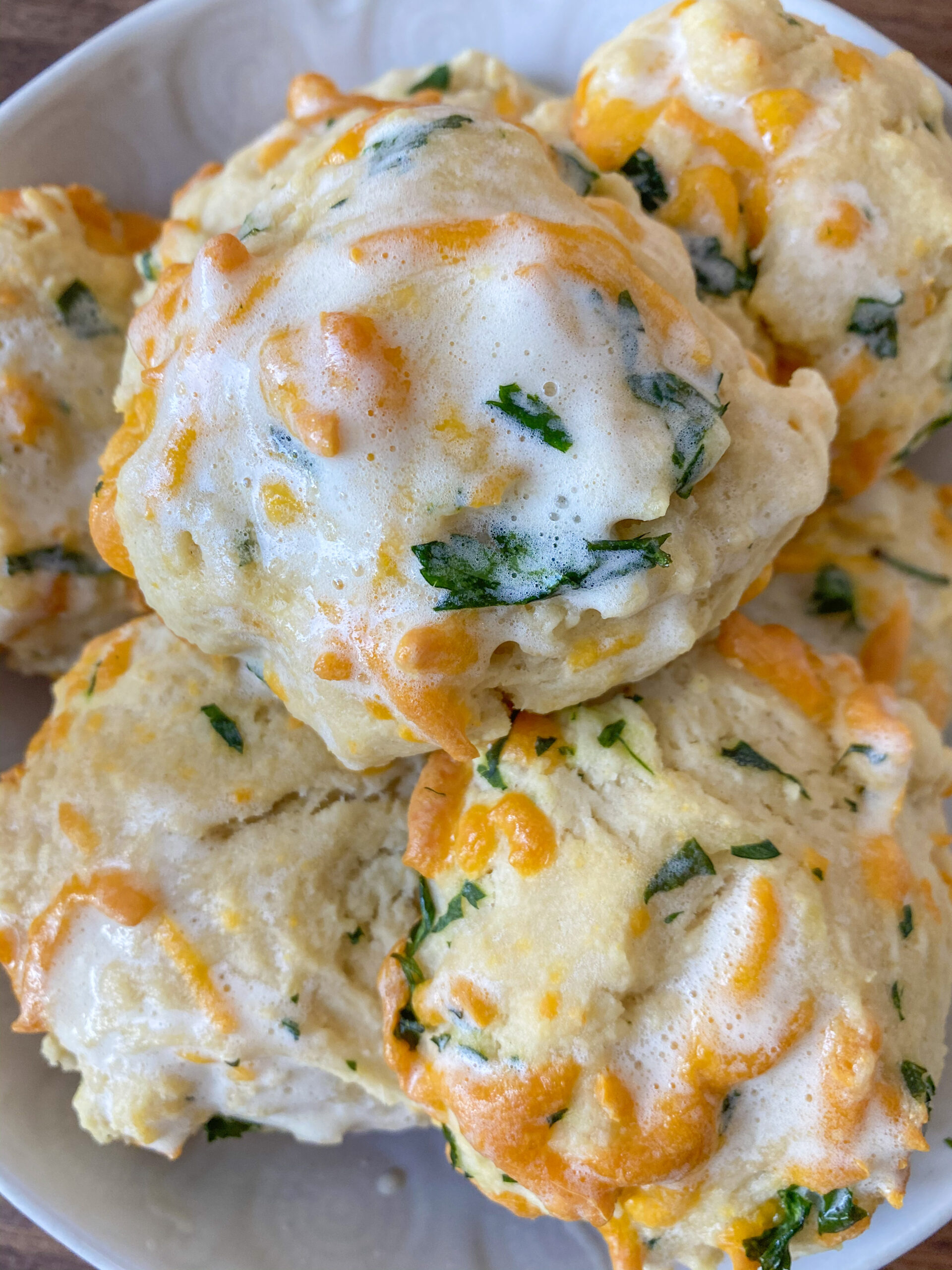 Cheddar bay biscuit with cheese, parsley, and melted butter on top.