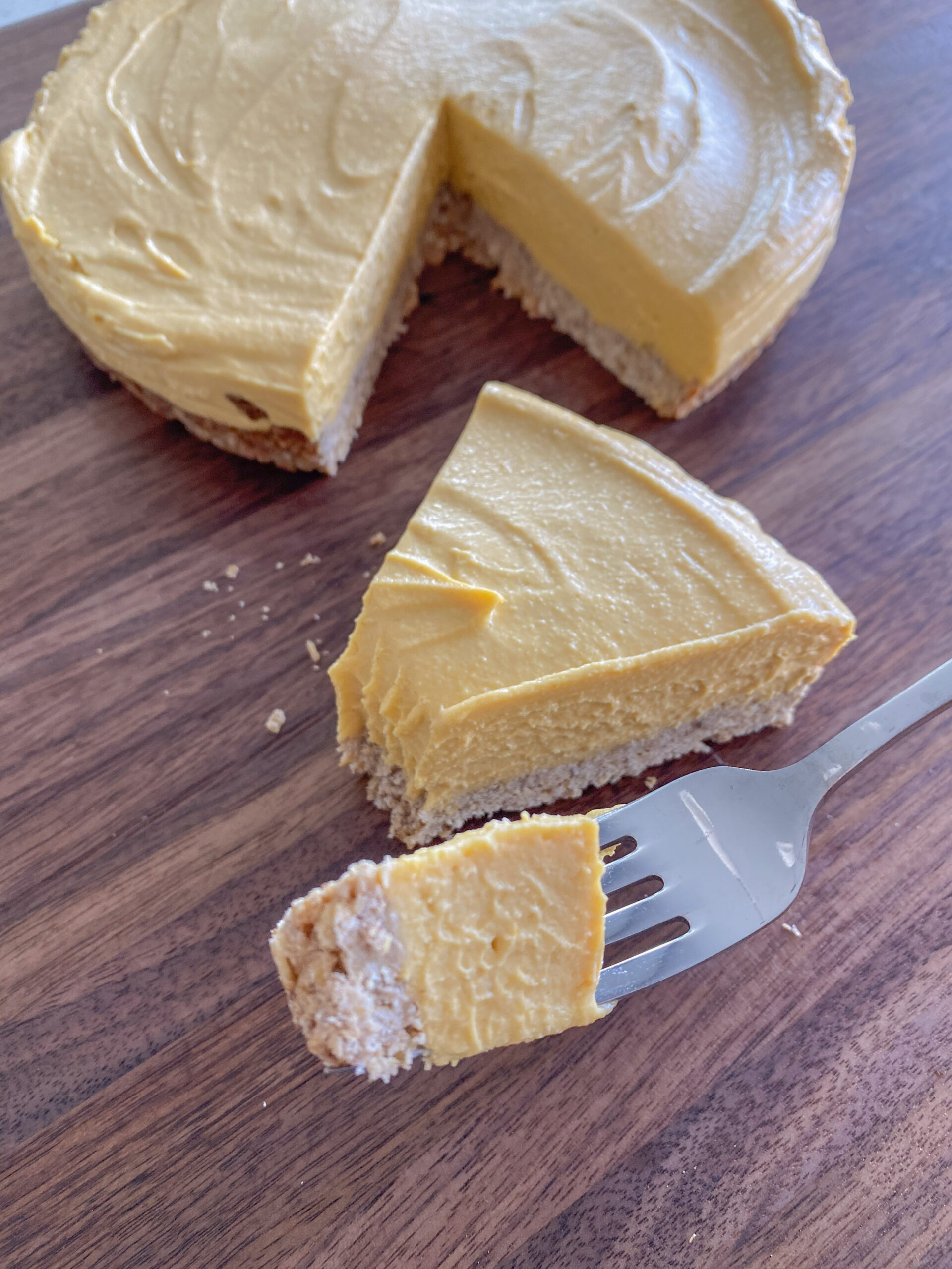 close up shot of a bite being taken from the pumpkin cheesecake