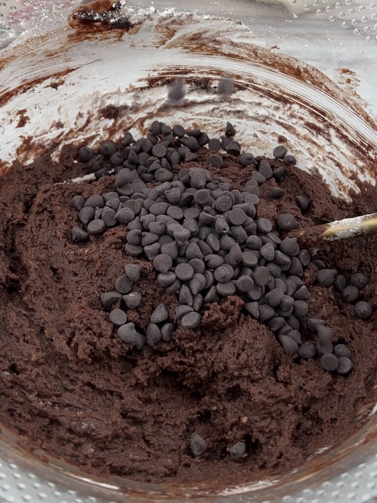 adding the vegan chocolate chips to the brownie batter