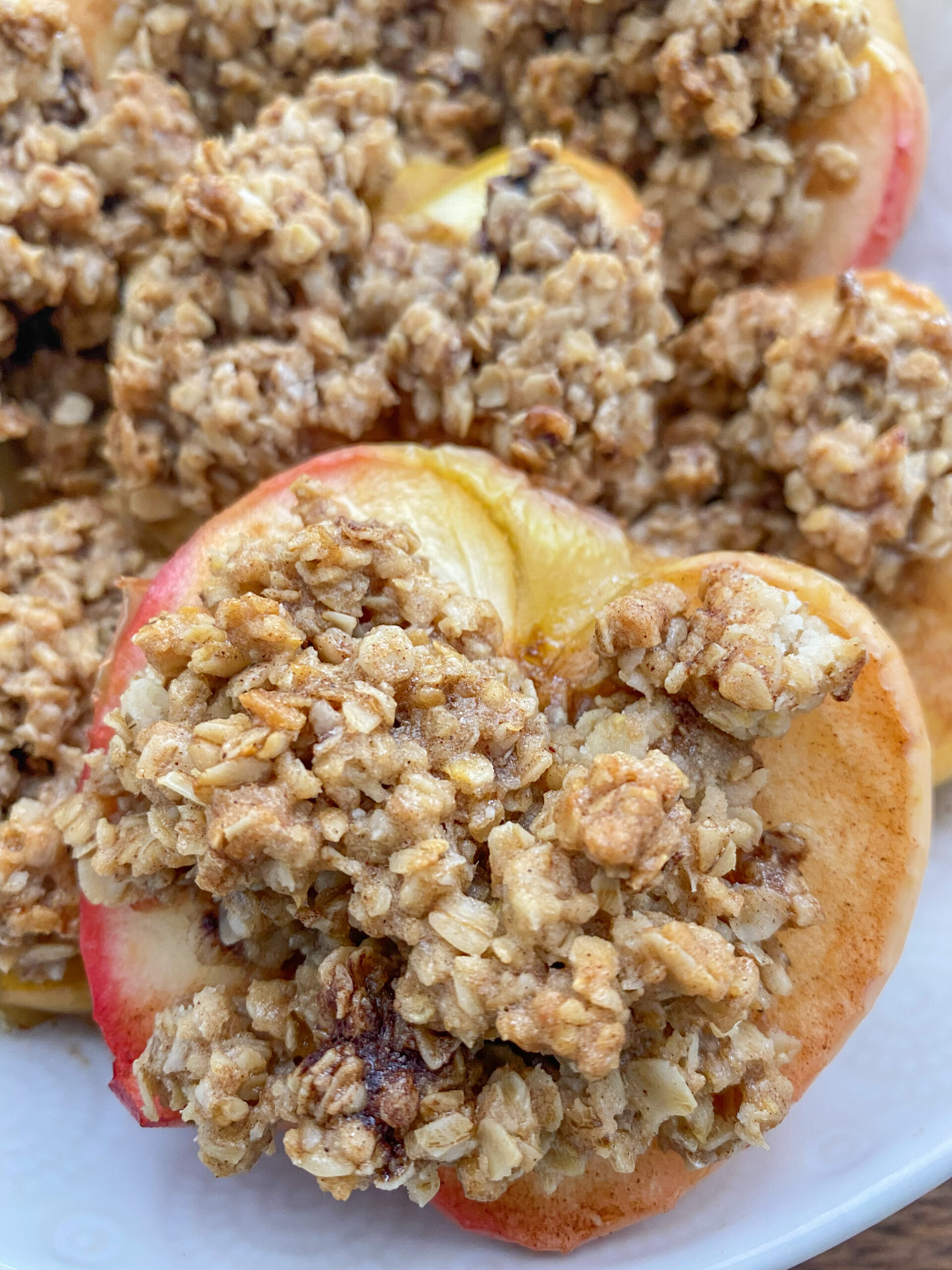 close up shot of a baked apple with cinnamon sugar oatmeal mixture. 