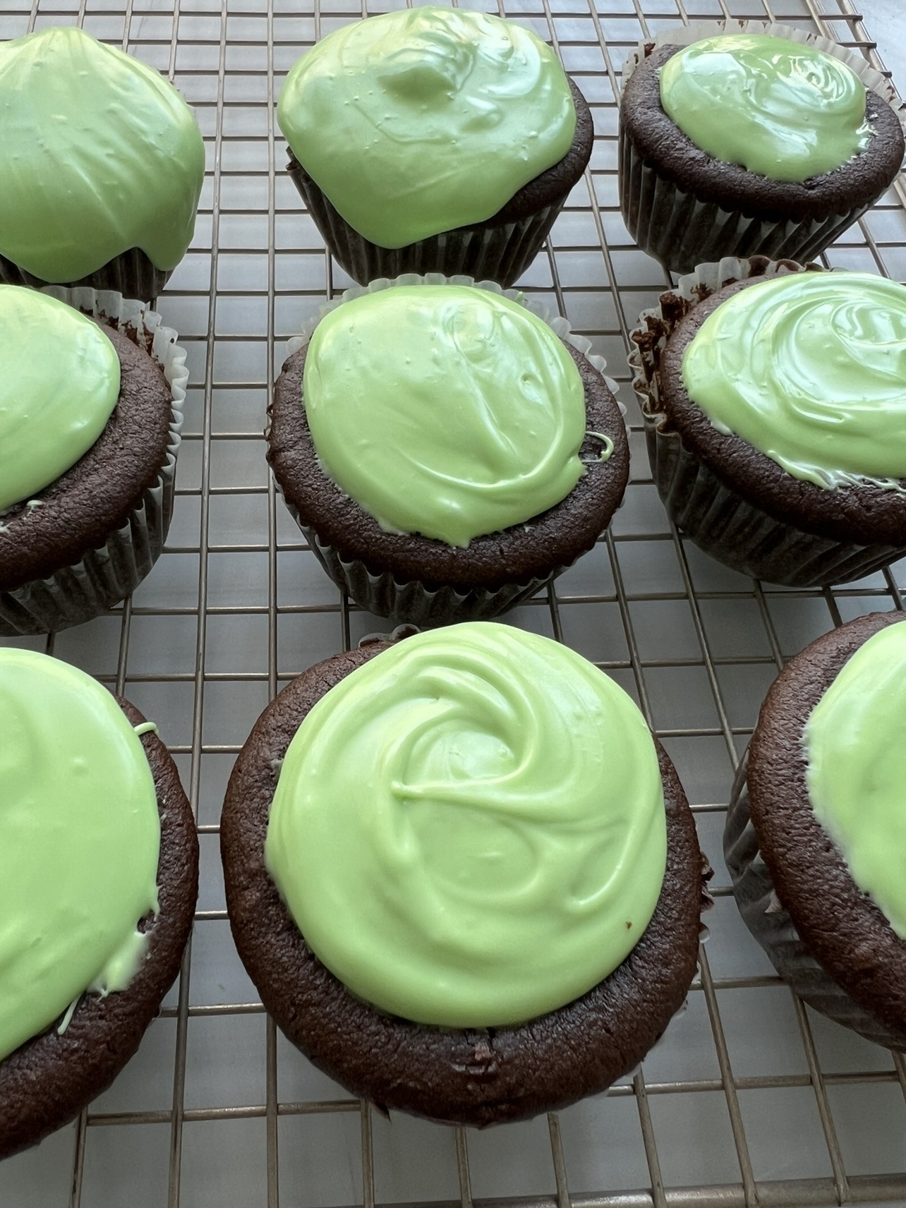 Step 5: Allow the cupcakes to cool before frosting and sprinkling them with green sprinkles. Enjoy!