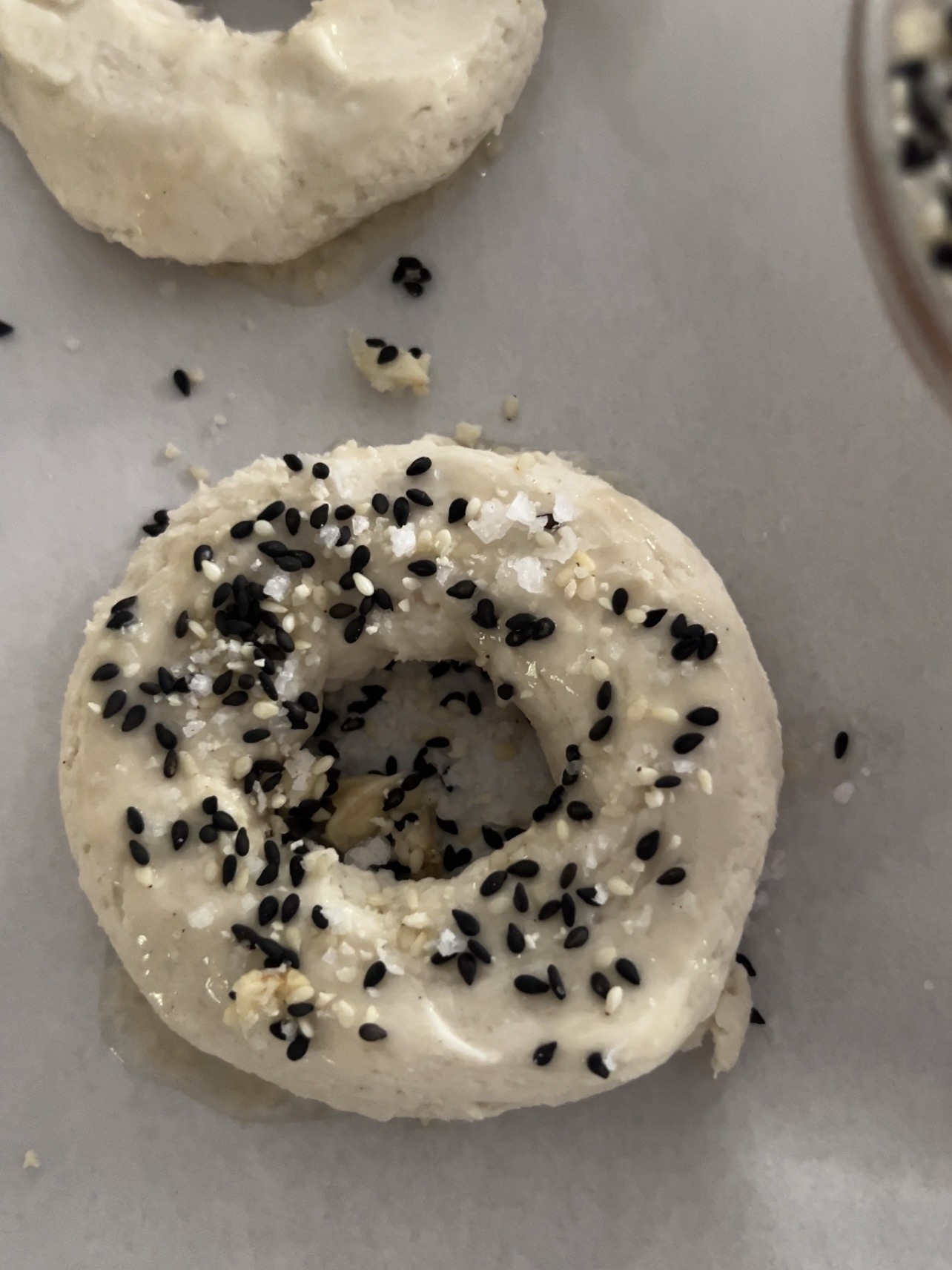 Bagel dough topped on parchment paper.