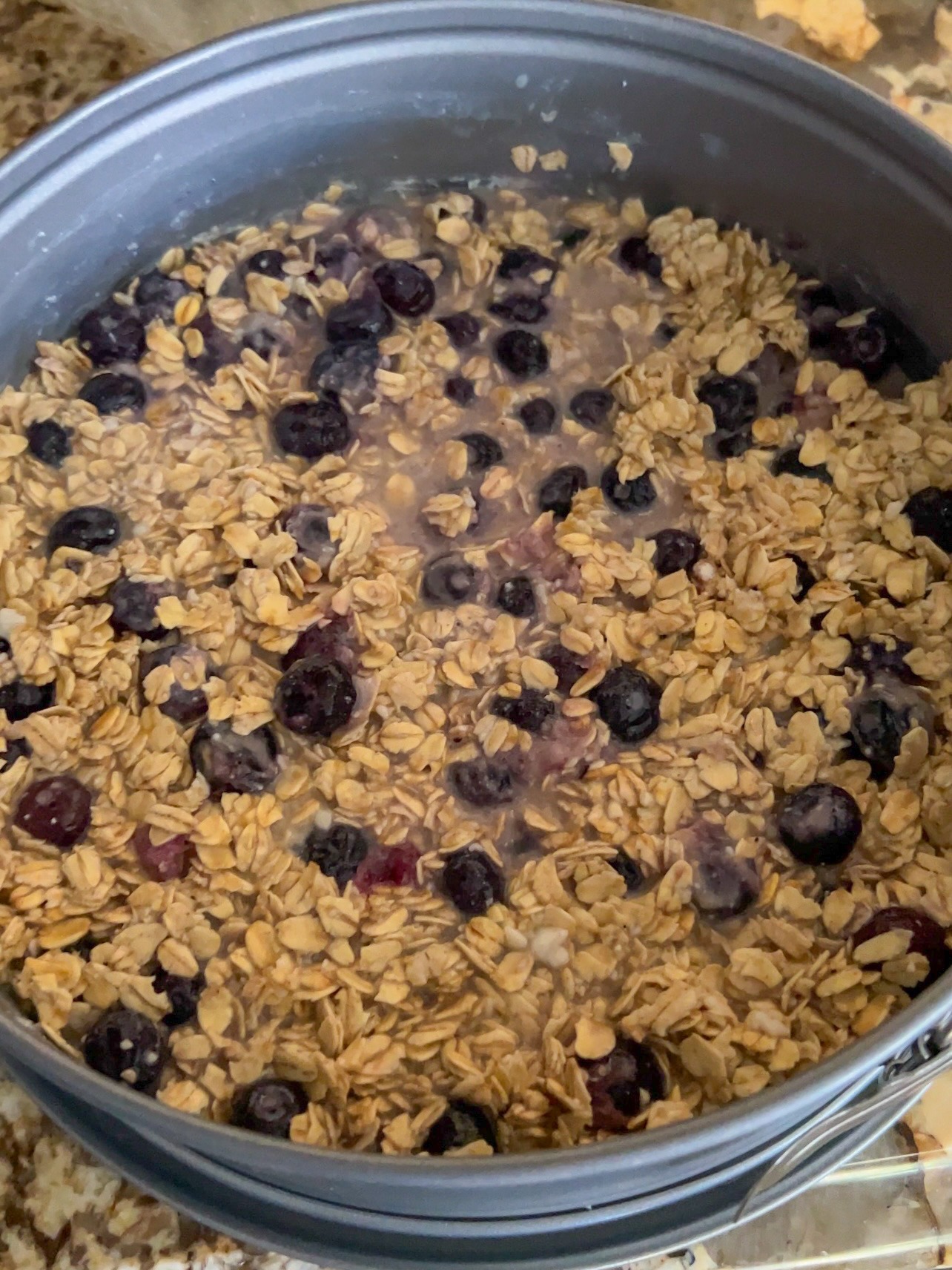 Adding blueberry and oat mixture to a pan for baking.
