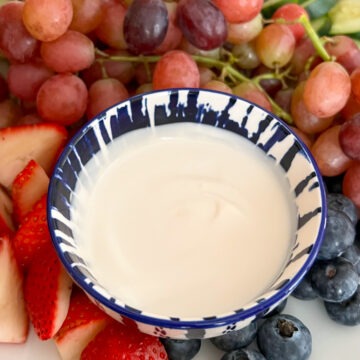 Creamy yogurt fruit dip in a bowl served with fresh fruit.