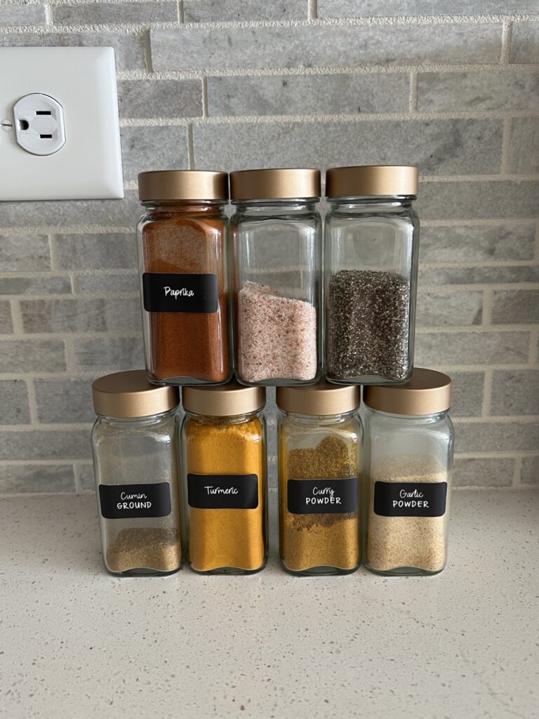 Spices needed for coconut curry casserole stacked on a kitchen counter. 