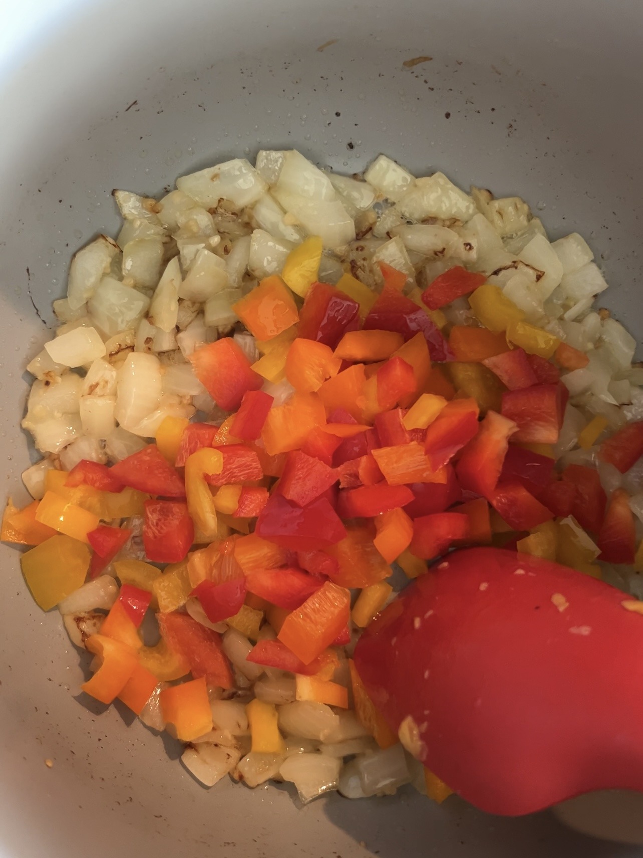 Sautéing onions and bell peppers in a large skillet.