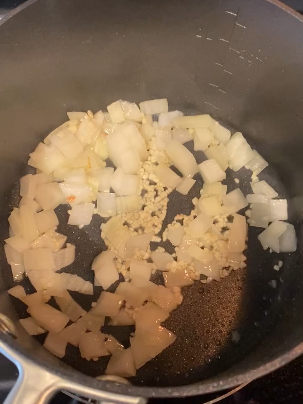Sautéing onion and garlic in a skillet.