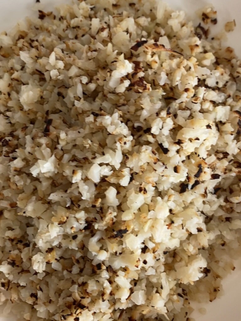 Cauliflower rice after being cooked with crispy ends. 