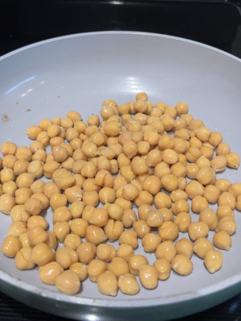 Cooking chickpeas in a skillet.