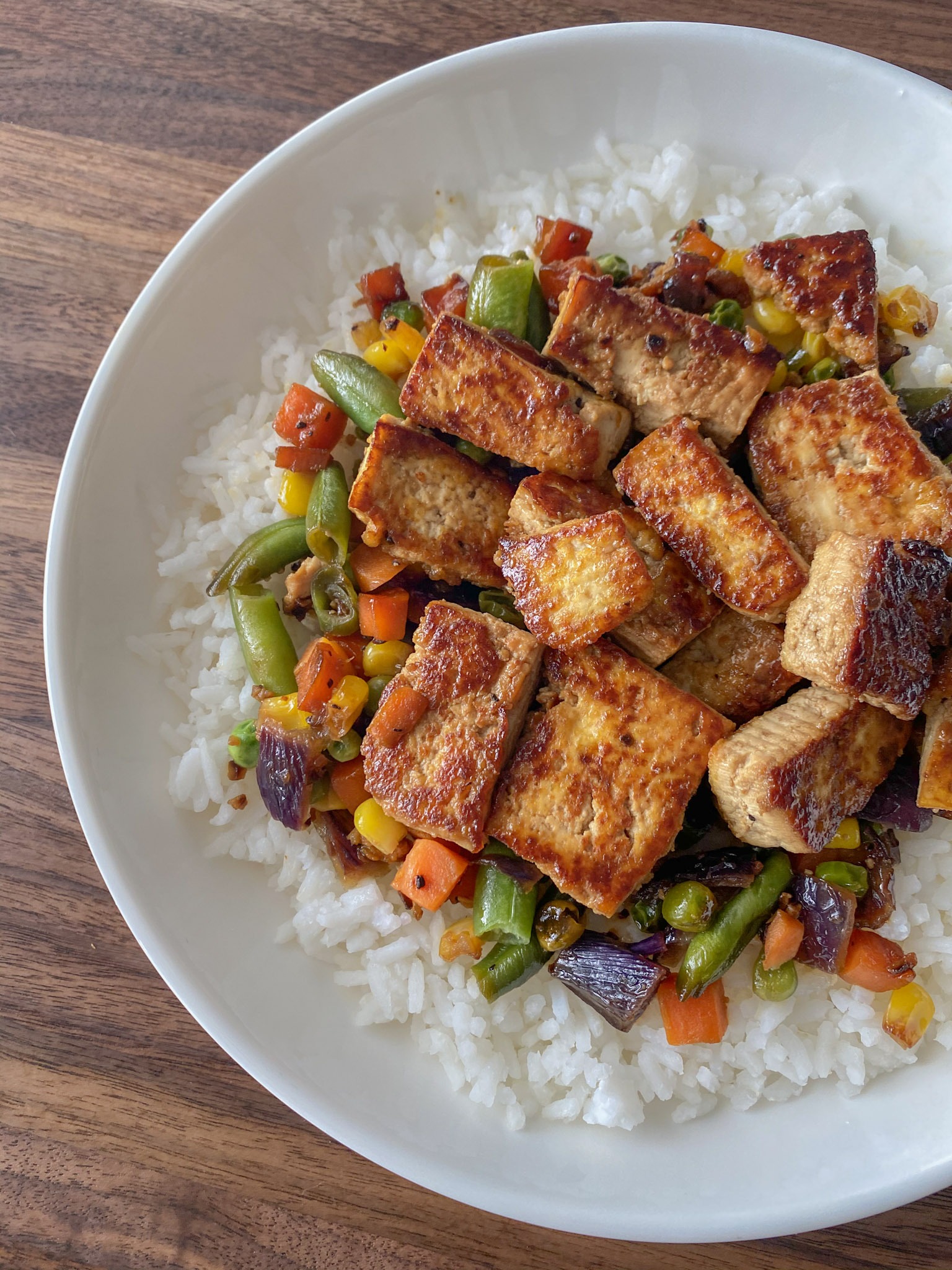 Tofu with vegetables served over white rice.