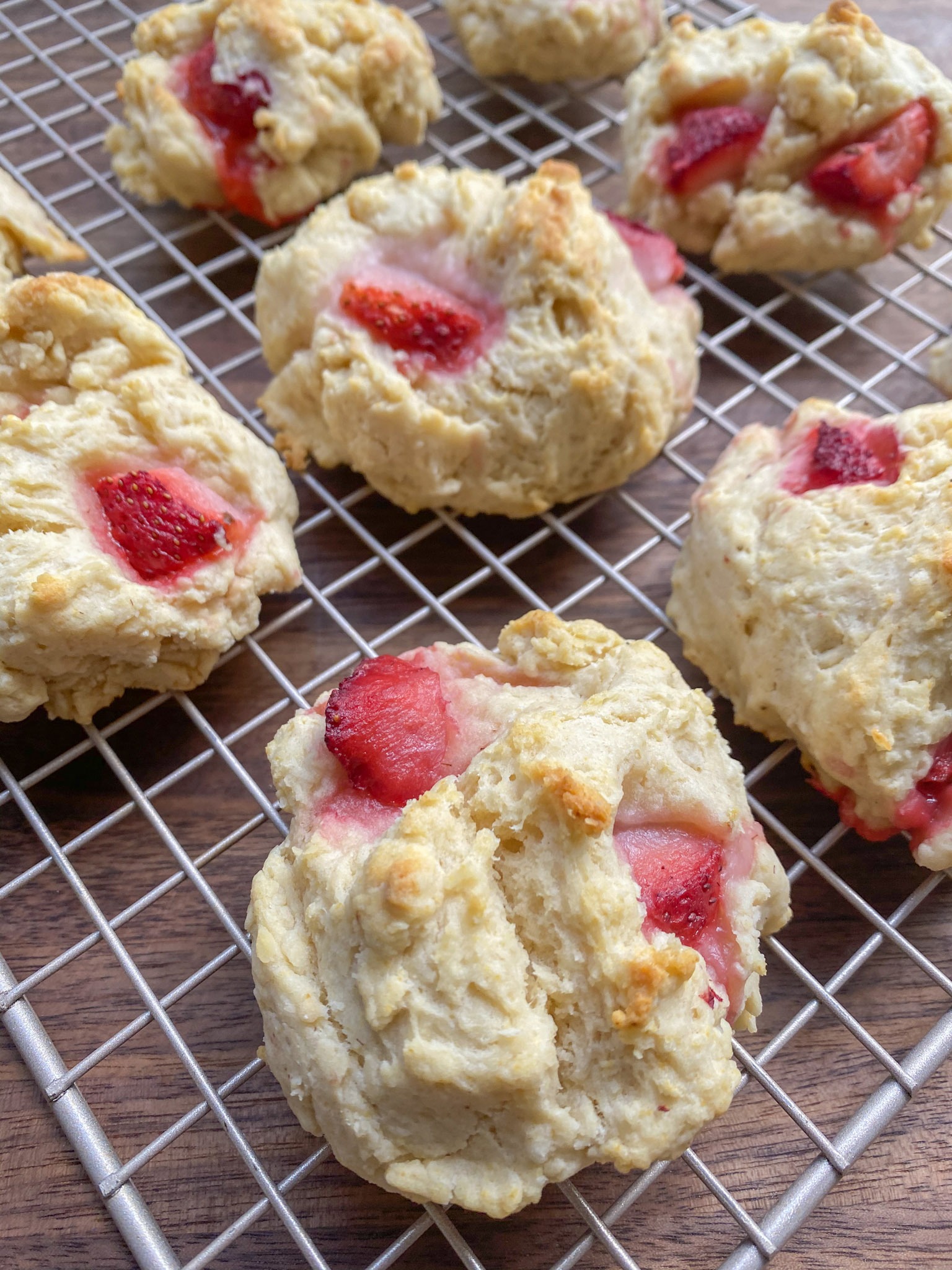 Baked vegan strawberry drop biscuits cooling on a cooling rack. 