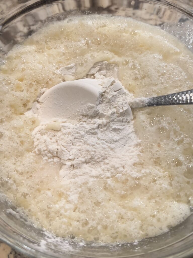 Stirring flour into wet ingredients.