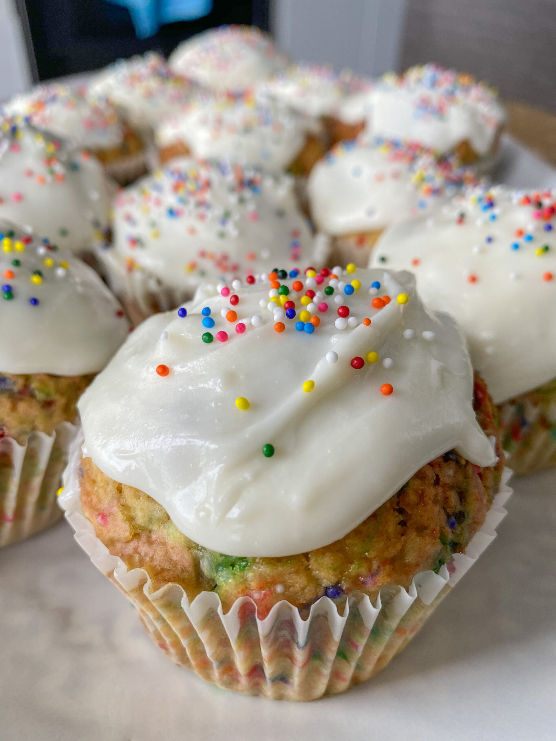 Funfetti cupcakes on a serving platter topped with frosting and sprinkles.