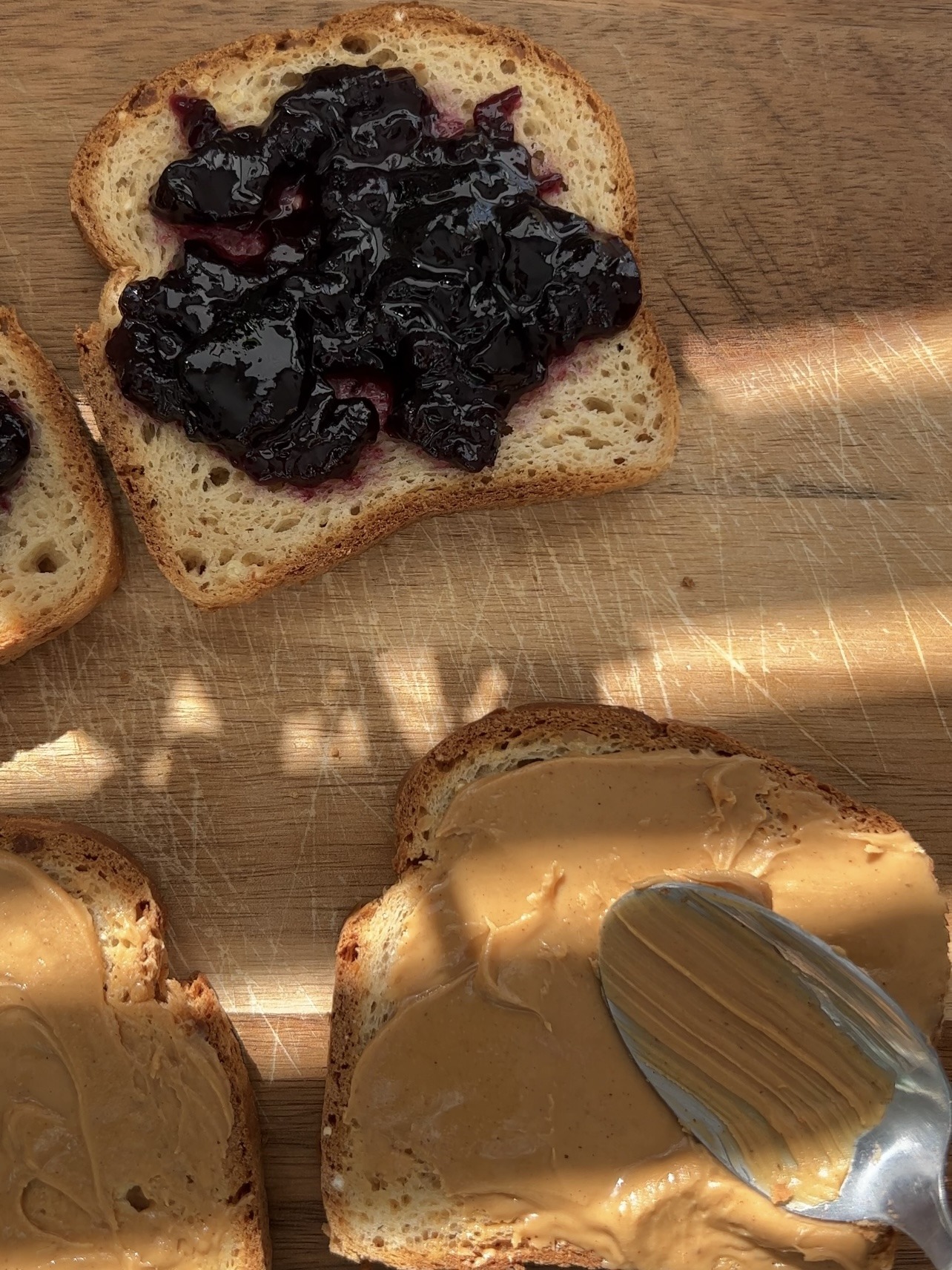 make two peanut butter and jelly sandwiches by spreading the peanut butter on two slices of bread, jelly on the other two slices of bread, and then putting each slice of bread with peanut butter on top of each slice of bread with jelly.