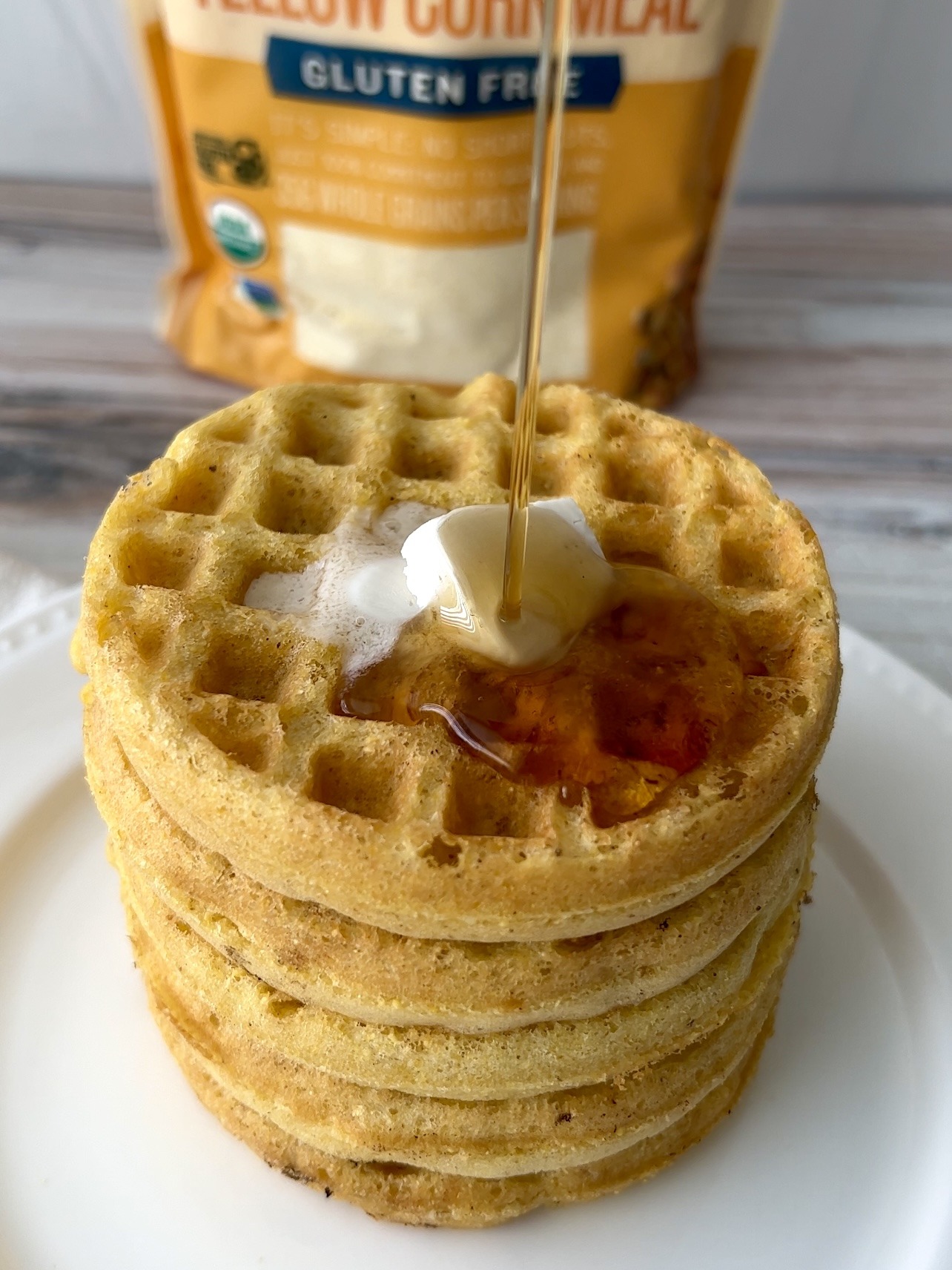 cornbread waffles with syrup being poured on top. 