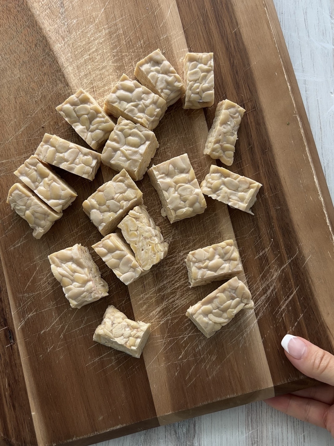 tempeh on cutting board after cutting it