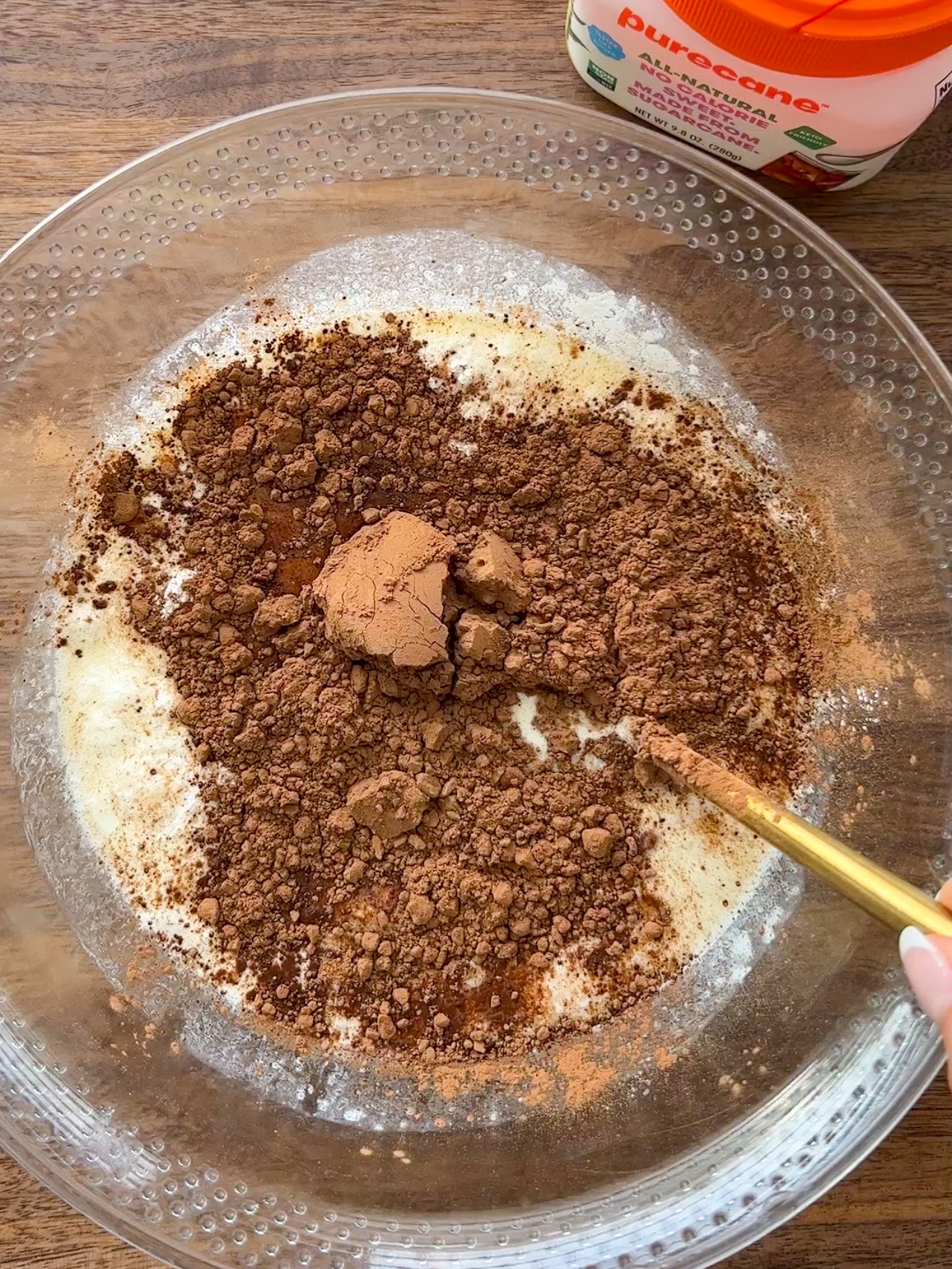 mixing the chocolate donut hole batter in a glass mixing bowl. 