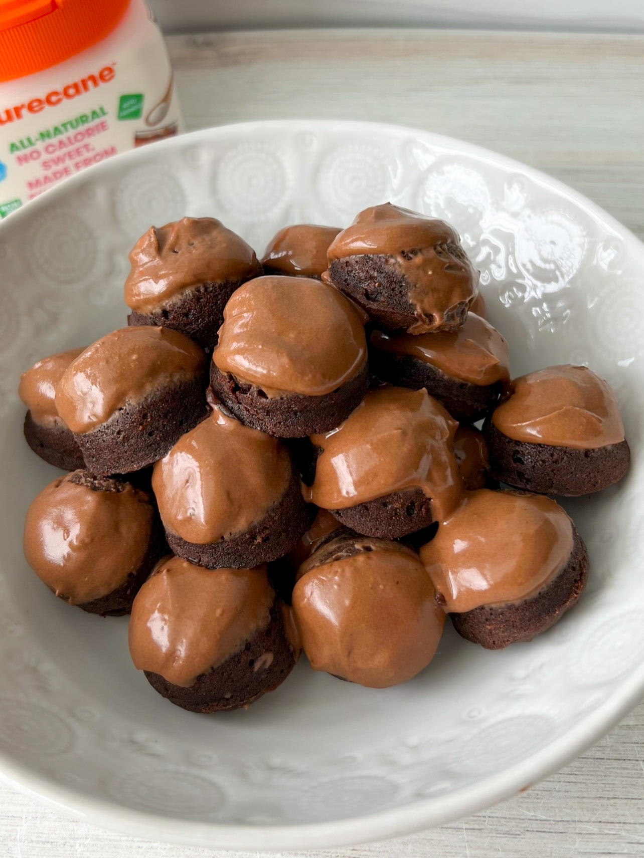 Chocolate donut holes topped with chocolate frosting. 