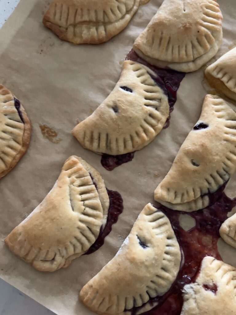 Baked hand pies on parchment paper.