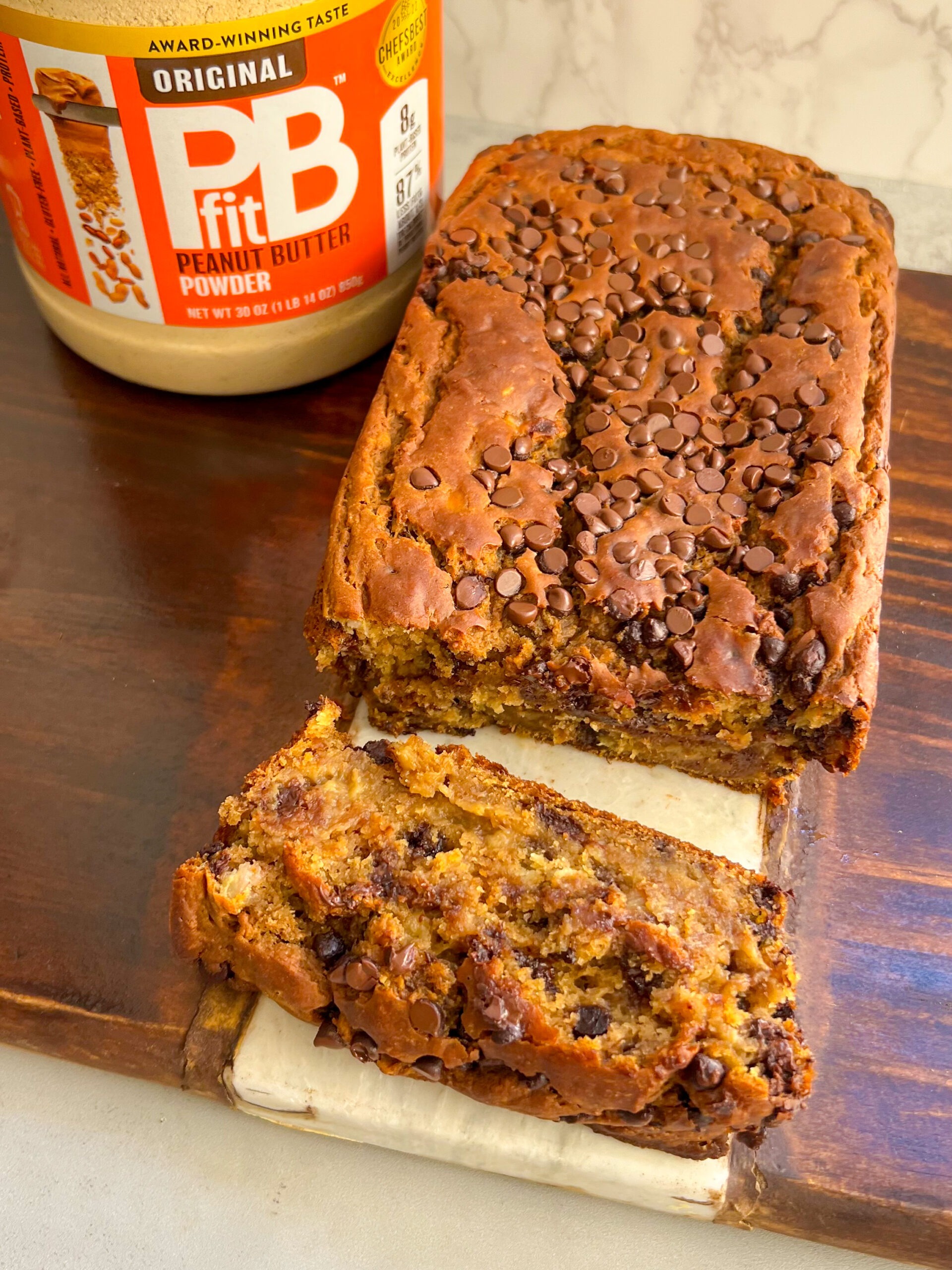 peanut butter banana bread - sliced with pbfit in the background