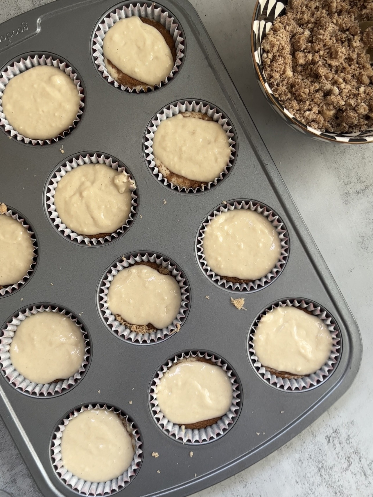 adding the streusel on top of each of the coffee cake cupcakes