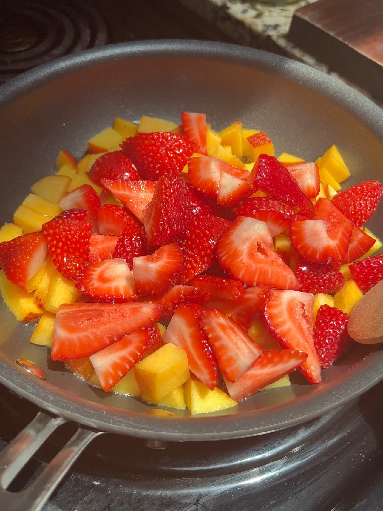 berries, peaches, and agave in a pan