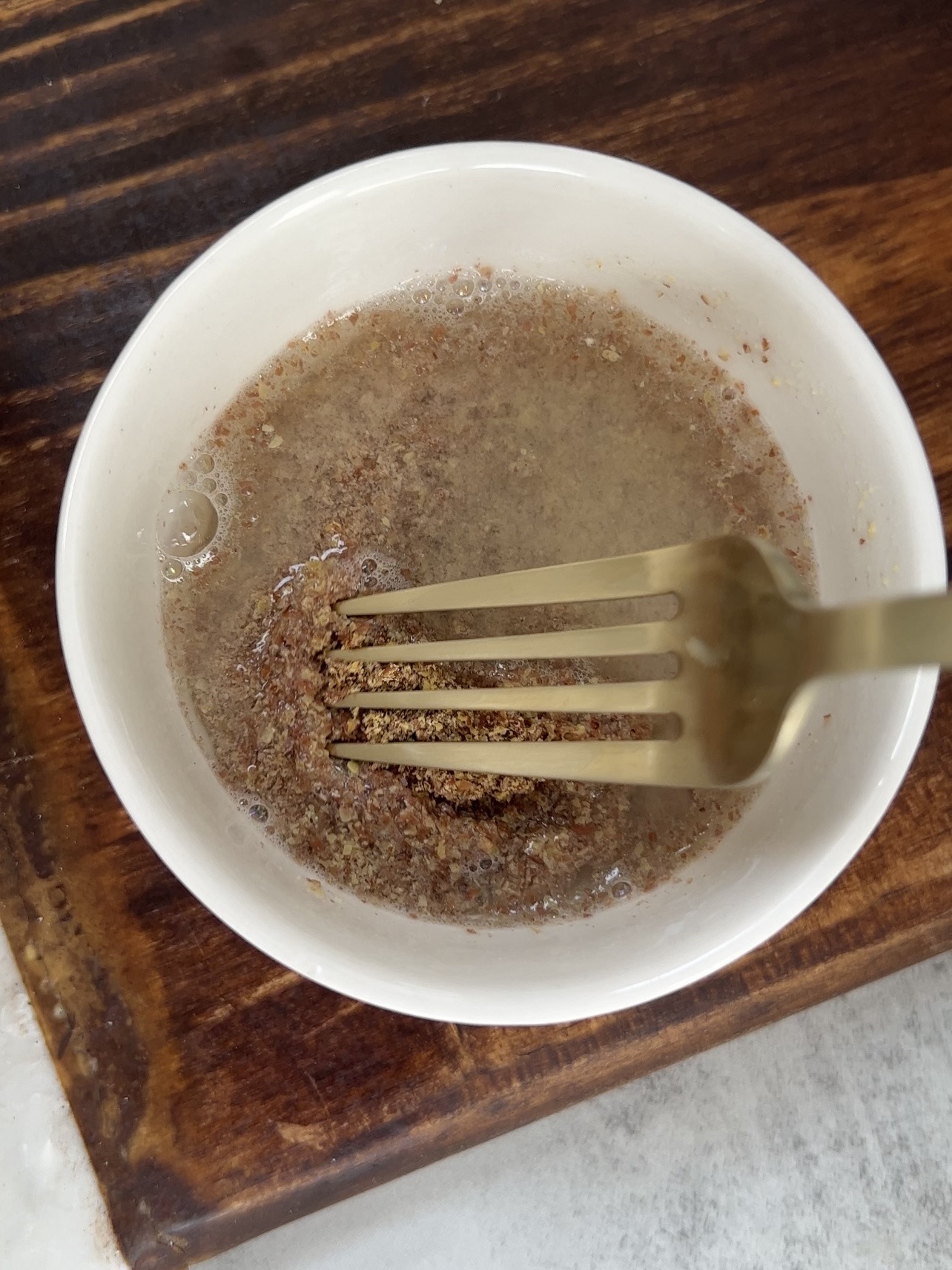 making the flax eggs by mixing the warm water and flax seed meal together