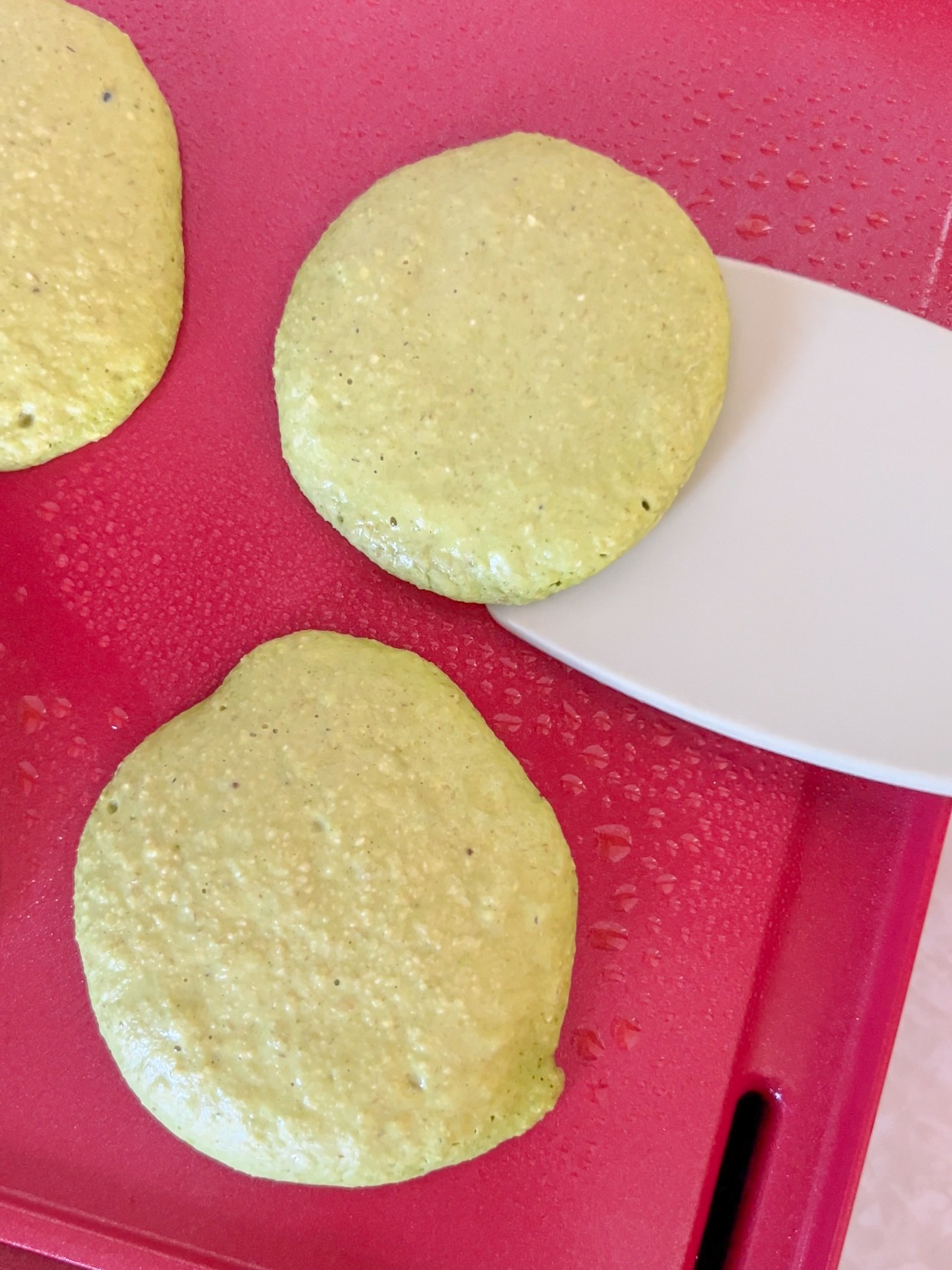 flipping the banana spinach pancakes on the griddle