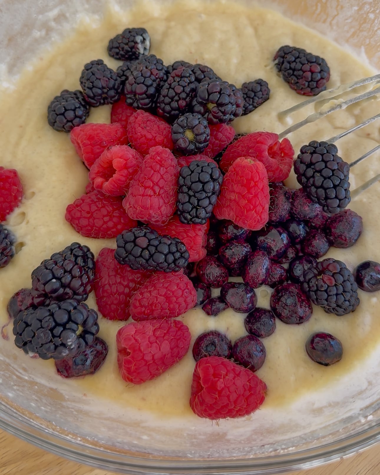 adding berries to the batter