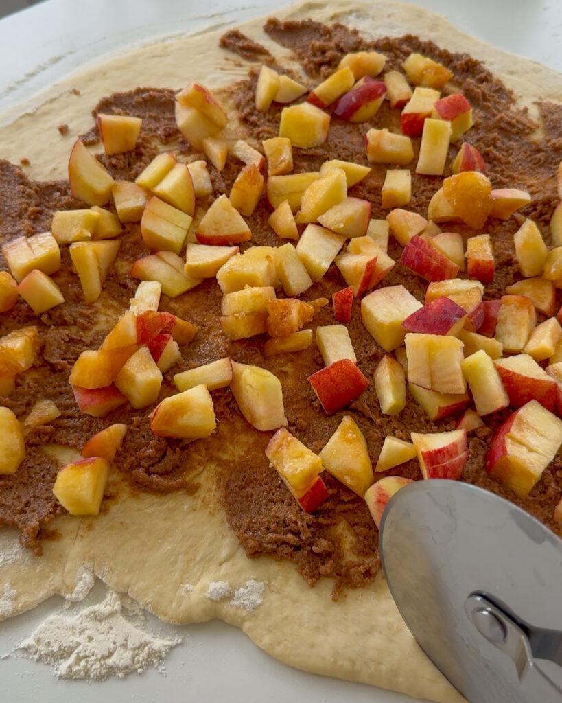 peach cobbler cinnamon rolls - spreading the filling and peaches